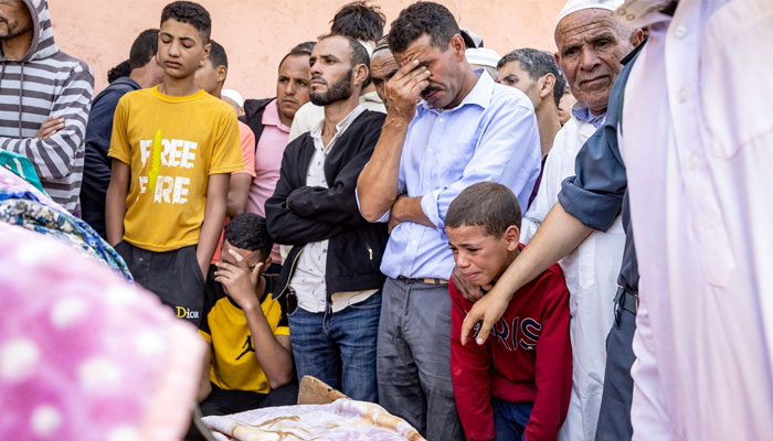People mourn in front of the body of a victim killed in an earthquake in Moulay Brahim, Al Haouz province, on September 9, 2023. — AFP