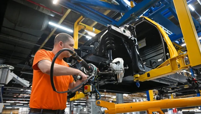 An emloyee works on the assembling of a brake caliper for an electric vehicle in Dueren, western Germany. — Reuters