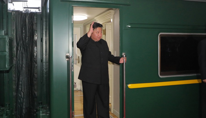 12 ستمبر 2023 کو جاری کی گئی اس تصویر میں شمالی کوریا کے رہنما کم جونگ ان کو روس کے دورے پر پیانگ یانگ سے نکلتے وقت اپنی بلٹ پروف ٹرین میں سوار ہوتے اور لہراتے ہوئے دکھایا گیا ہے۔  - کے سی این اے