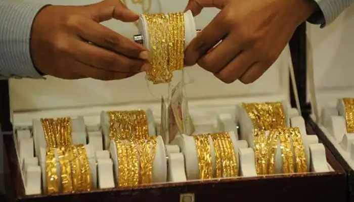 A trader displays gold bangles at a jeweller shop in this undated photo. — AFP