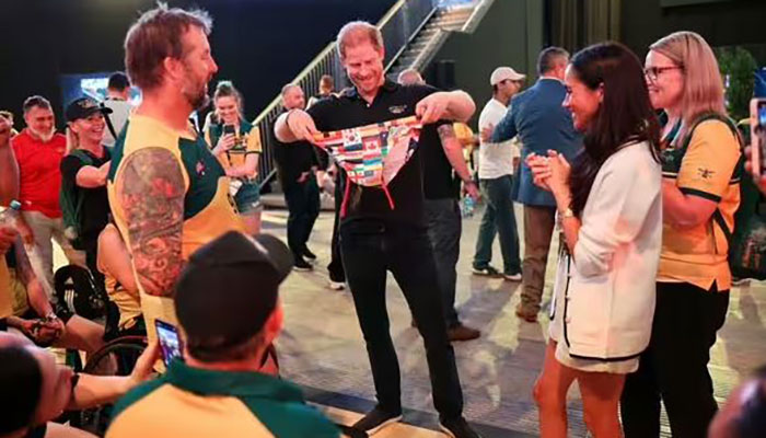 Prince Harry given a pair of swim trunks as Meghan Markle watches on at the 2022 Invictus Games