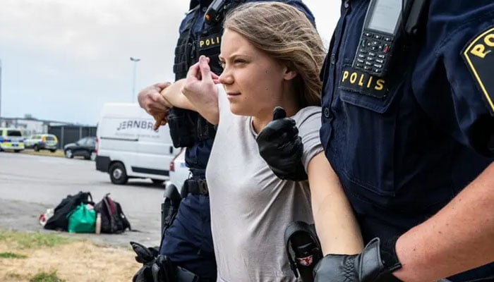 Greta Thunberg being moved by male police officers at a climate protest in Malmö in June. — AFP
