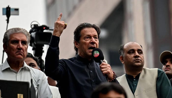 PTI Chairman Imran Khan addressing a public gathering in this undated picture alongside Shah Mahmood Qureshi. — AFP/File