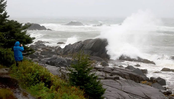 A resident takes a photo of the gushing waves in the sea as Storm Lee approaches. — AFP/File