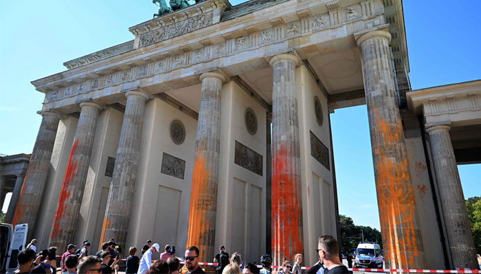 The columns of Berlin´s landmark the Brandenburg Gate are covered in orange paint on September 17, 2023, in Berlin, Germany.—AFP