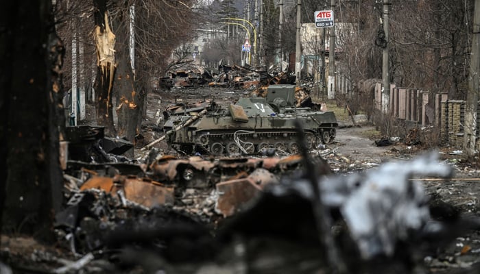 4 مارچ 2022 کو لی گئی اس تصویر میں روس-یوکرین جنگ کے دوران کیف کے مغرب میں واقع بوچا شہر کی ایک سڑک پر ماسکو کی تباہ شدہ بکتر بند گاڑیوں کو قطار میں کھڑا دکھایا گیا ہے۔  - اے ایف پی