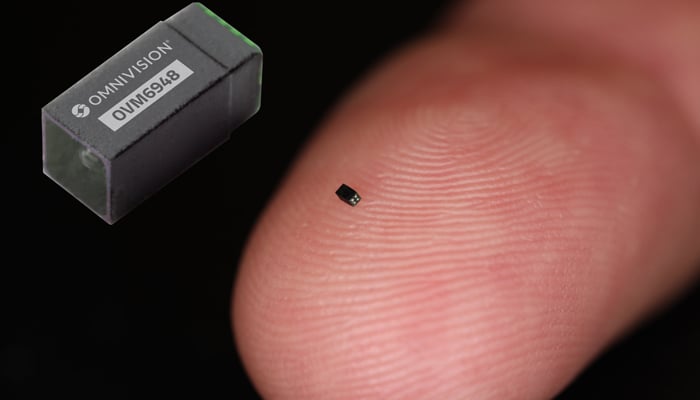 A tiniest camera, smaller than a grain of salt can be seen in this picture on a finger. — OmniVision Technologies