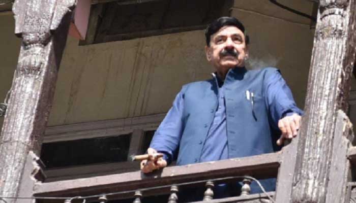 AML chief Sheikh Rashid Ahmed is smoking a cigar while standing on a balcony of his Lal Haveli residence in Rawalpindi.  — Facebook/SheikhRasheed/File