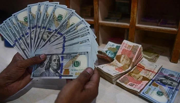 A foreign currency dealer counts US dollars at a shop in Karachi on May 19, 2022. — AFP