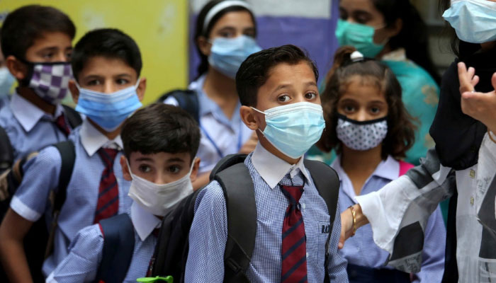 Students wearing face masks to prevent the spread of the coronavirus arrive at a primary school. — AFP/File