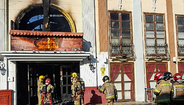 This handout photograph taken and released on October 1, 2023, by the 112 Emergency Services of the Murcia Region shows firefighters entering the Teatre nightclub as at least thirteen people were killed in a fire, in Murcia.—AFP