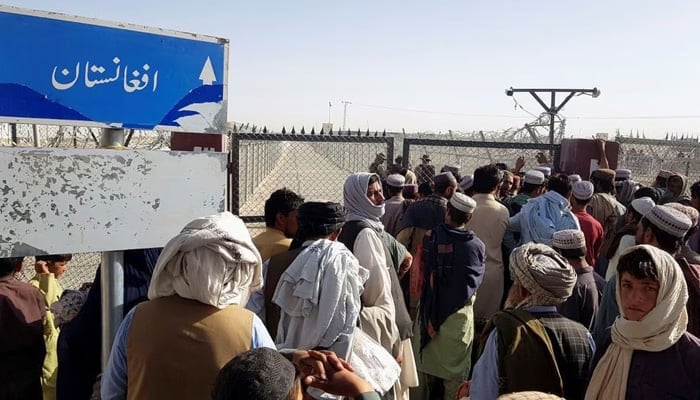 People gather as they wait to cross at the Friendship Gate crossing point in the Pakistan-Afghanistan border town of Chaman, on August 12, 2021. — AFP