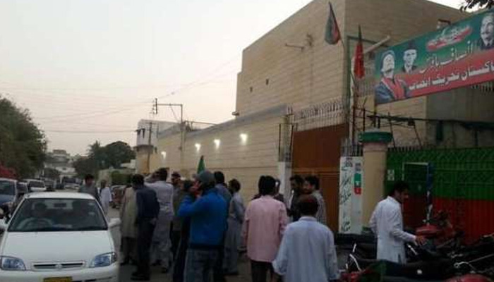 PTI workers stand outside the Insaf House in Karachi in this file photo. — PTI/Facebook
