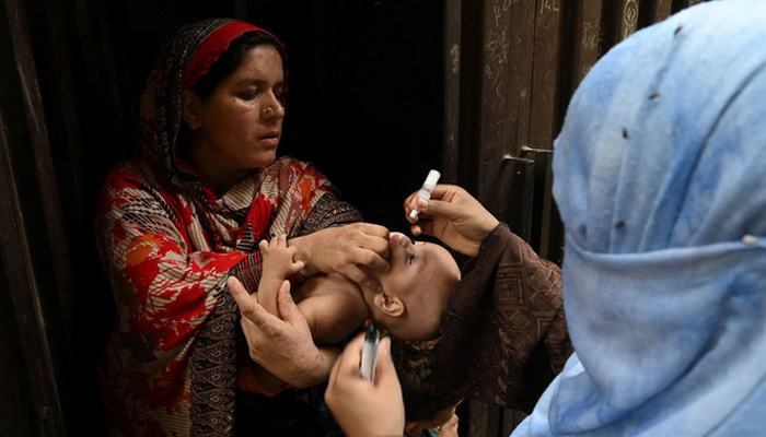 A health worker administers polio vaccine drops to a child during a polio vaccination campaign at a slum area in Lahore, Pakistan, on August 2, 2021. — AFP