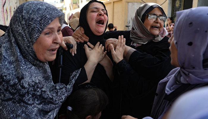8 اکتوبر 2023 کو جنوبی غزہ کی پٹی کے فلسطینی شہر رفح پر اسرائیلی حملوں میں ہلاک ہونے والے ابو قطہ خاندان کے افراد کی نماز جنازہ کے دوران خواتین ماتم کر رہی ہیں۔ — اے ایف پی