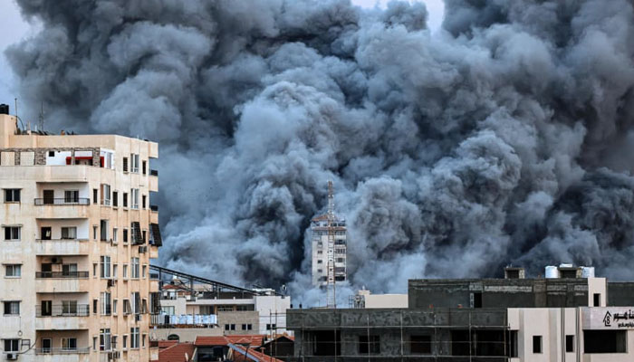 A plume of smoke rises above buildings in Gaza City on October 7, 2023, during an Israeli air strike. — AFP