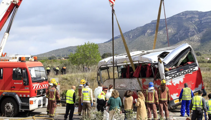 A bus is being lifted by a crane after a crash. — AFP/File