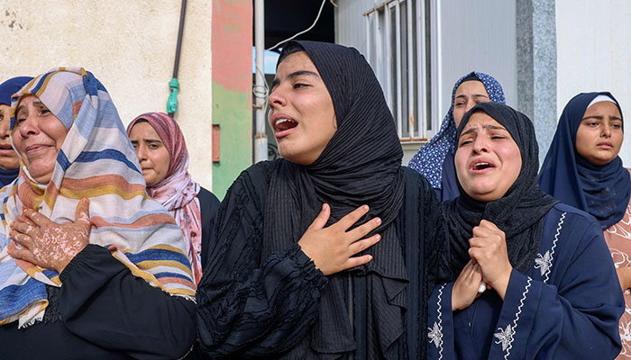 People mourn during the funeral of Palestinians killed in overnight Israeli shelling in Khan Yunis in the southern Gaza Strip, on October 10, 2023. — AFP