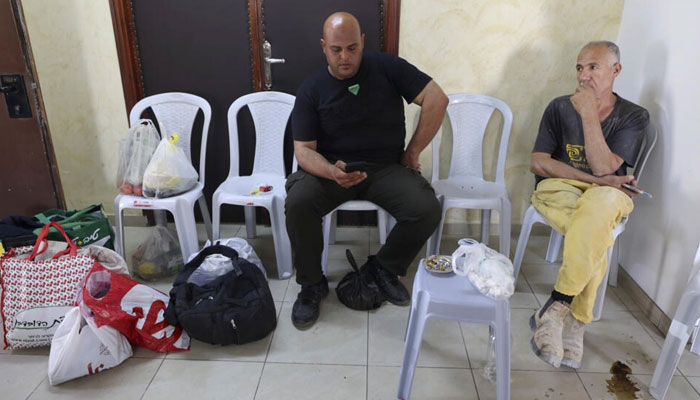 غزہ سے تعلق رکھنے والے فلسطینی اسرائیلی مقبوضہ مغربی کنارے میں پھنسے ہوئے ہیں، رام اللہ میں ایک ہوٹل کے کمرے میں خبر کی پیروی کرتے ہیں۔ اے ایف پی