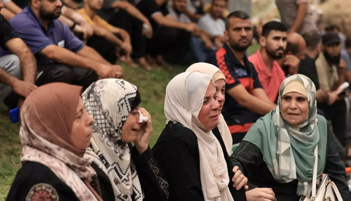 9 اکتوبر 2023 کو غزہ کی پٹی میں جبالیہ پناہ گزین کیمپ پر اسرائیلی فضائی حملے کے بعد فلسطینی اپنے رشتہ داروں کی موت پر سوگ منا رہے ہیں۔ - اے ایف پی