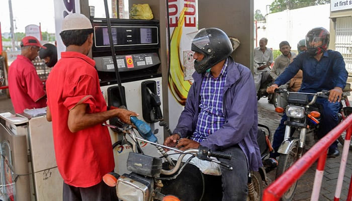 An employee of a gas station fills the tank of a motorbike in Karachi, on July 16, 2021. — AFP