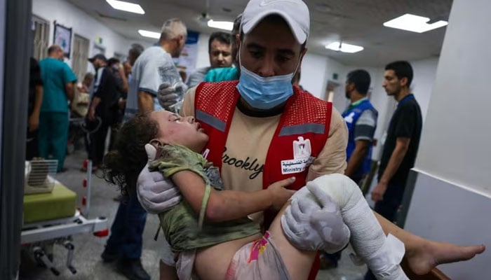 An emergency responder carries a wounded child in a hospital following Israeli airstrikes in Rafah, southern Gaza Strip, on Friday. — AFP