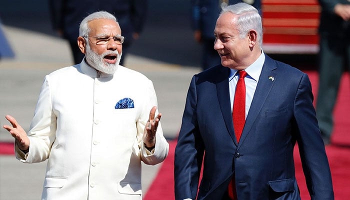 Israeli Prime Minister Benjamin Netanyahu (R) walks with his Indian counterpart Narendra Modi (L) during an official ceremony at Ben-Gurion International Airport near Tel Aviv on July 4. — AFP
