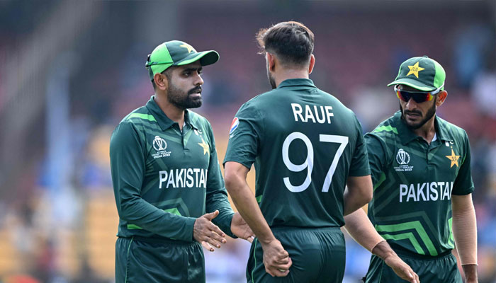 Pakistan´s captain Babar Azam (left) talks with his teammate Haris Rauf (C) during the 2023 ICC Men´s Cricket World Cup match between Australia and Pakistan at the M. Chinnaswamy Stadium in Bengaluru on October 20, 2023. — AFP