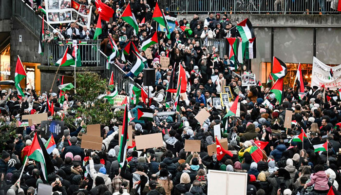 Demonstrators wave flags and display placards during a demonstration in solidarity with Palestinians in the Gaza Strip, at Sergel´s Square in Stockholm, Sweden, on October 22, 2023, in reaction to the war between Israel and Palestine. ÿ AFP