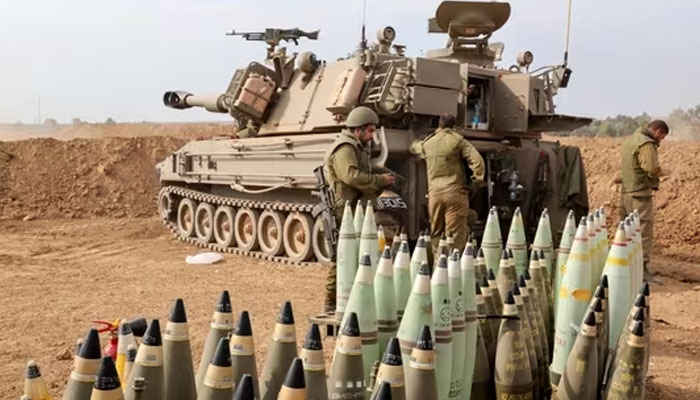 Artillery shells are lined up next to an armoured vehicle as Israeli soldiers take positions near the border with Gaza in southern Israel on October 9. — AFP