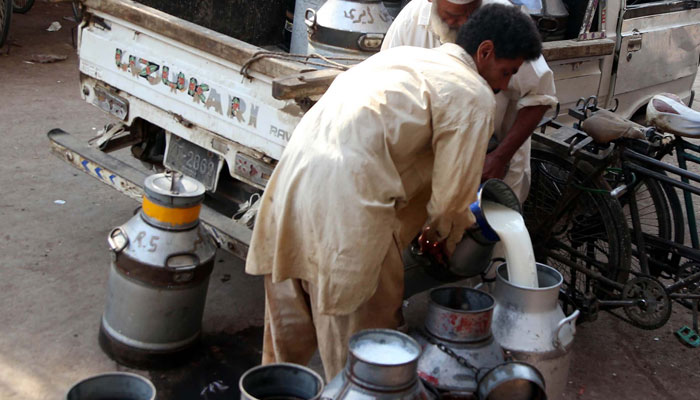 Dairy farmer selling milk at milk market in Karachis Lyari neighbourhood on November 7, 2021. — PPI