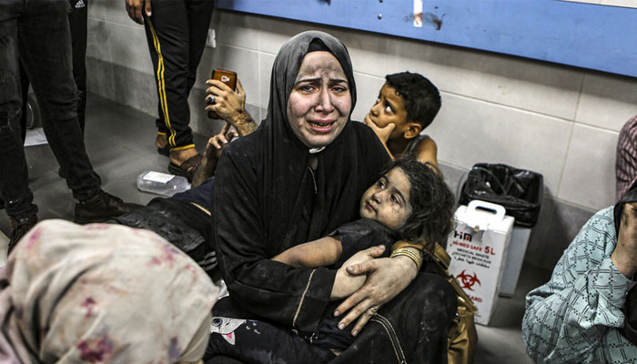 Wounded Palestinians sit in al-Shifa hospital in Gaza City, central Gaza Strip, after arriving from Al-Ahli hospital following an explosion there, on Tuesday. — X@ap