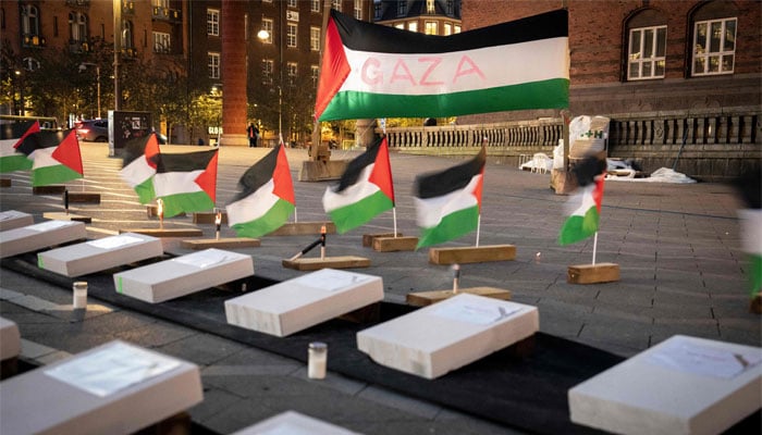 Palestinian flags are placed next to hundreds of mock children´s coffins are placed on City Hall Square to symbolize the number of dead Palestinian children in the conflict between Hamas and Israel, during a memorial service under the motto children pay the price, that is held on City Hall Square in Copenhagen, on October 27, 2023. — AFP