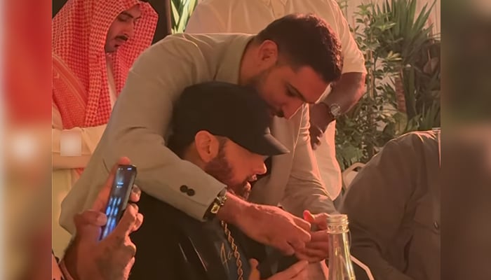Amir Khan wraps a watchs band around Eminems hand in this still taken from a video. — Instagram/@amirkingkhan