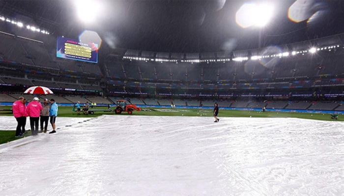A cricket ground is seen partially covered with sheets after a spell of rain during a match. — AFP/File