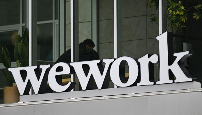 The WeWork logo is displayed outside of an office space rental location in Santa Monica, California on March 20, 2023. — AFP