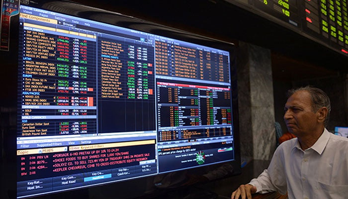 Stock broker monitor television screen at a booth, during a trading session at the Pakistan Stock Exchange, in Karachi, Pakistan. — AFP/File