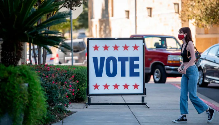 A woman passing by a vote sign in Texas. — AFP/File