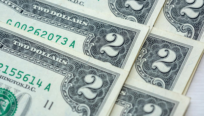 2$ dollar bills kept on a table. — X/@alamy