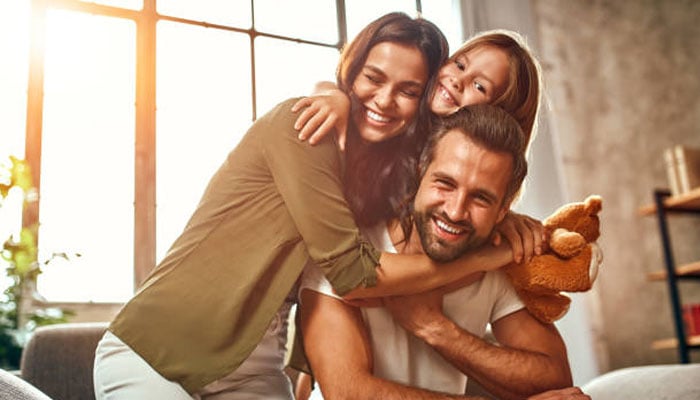 A US family hugging each other in their apartment. — X/@istock
