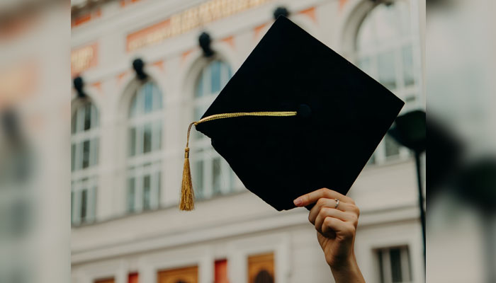 This representational image shows an unidentified individual holding a graduation cap. — Unsplash/File