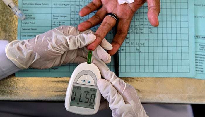 A woman getting her blood sugar level checked. — AFP/File