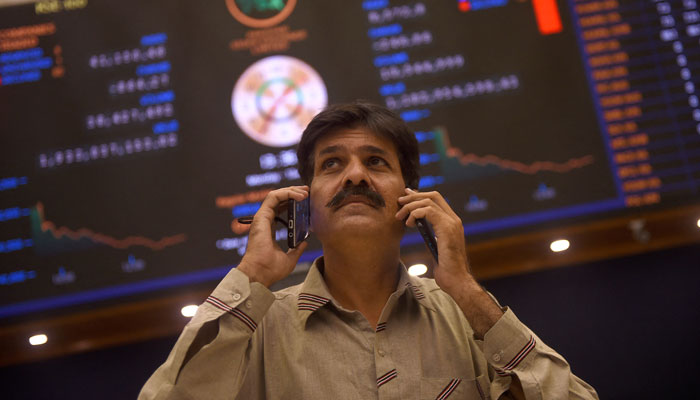 An investor at the KSE-100 Index talking on the phone in this undated picture. — AFP/File