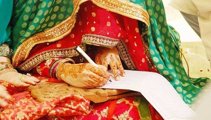 Representational image of a bride signing a marriage certificate. — AFP/File