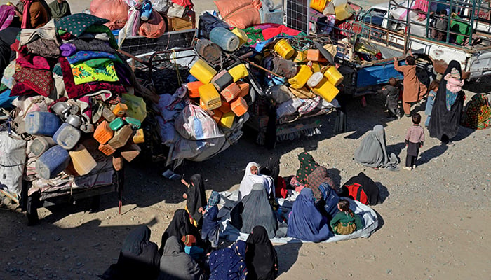 Afghan refugees sit beside their belongings at a registration centre, upon their arrival from Pakistan near the Afghanistan-Pakistan border in the Spin Boldak district of Kandahar province on November 20, 2023. — AFP
