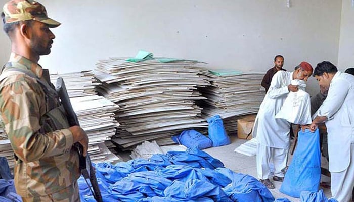 Returning office staff packing election material during handing over to authorities concerned at a session court under the supervision of the Pakistan Army in this undated image. — APP