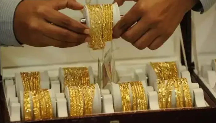 A trader displays gold bangles at a jeweller shop in this undated photo. —  AFP file