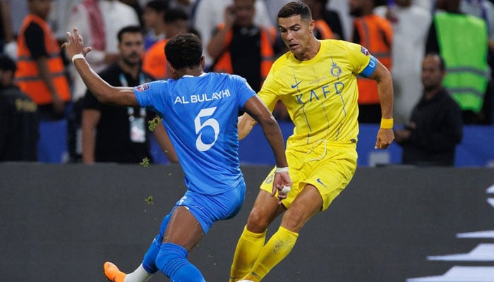 Ali AlBulayhi (left) fights for the ball with Nassr´s Portuguese forward Cristiano Ronaldo during the 2023 Arab Club Champions Cup final football match between Saudi Arabia´s Al-Hilal and Al-Nassr at the King Fahd Stadium in Taif on August 12, 2023. — AFP