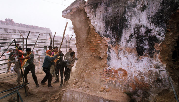 Indian Hindu fundamentalists attack the wall of the 16th century Babri Masjid Mosque with iron rods at a disputed holy site in the city of Ayodhya on December 6, 1992. — AFP