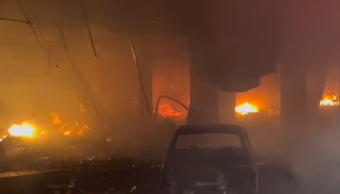 A completely destroyed car outside the building that caught fire near Karachi’s Ayesha Manzil, on December 6, 2023, in this still taken from a video. — Thenews.com.pk via Syed Daniyal Syed
